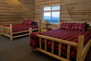 Carpeted bedroom featuring log walls