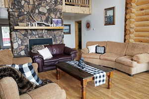 Living area featuring wood finished floors and a stone fireplace