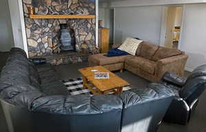 Carpeted living room with a wood stove