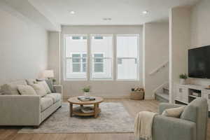 Living area featuring stairs, light wood-type flooring, and recessed lighting