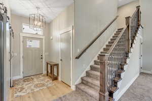 Entryway featuring a barn door, light wood-style floors, and a chandelier