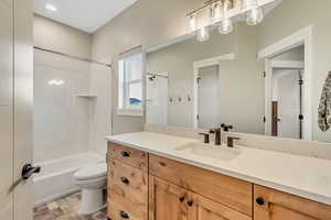 Full bath with vanity, shower / tub combination, and stone finish floors