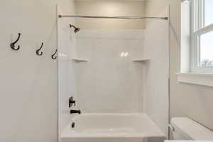 Bathroom featuring bathing tub / shower combination and toilet