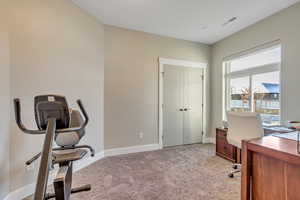 Home office featuring light carpet and baseboards