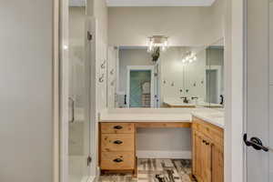 En-suite primary bathroom featuring vanity and a shower stall