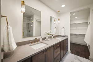 Bathroom with double vanity, a stall shower, a walk in closet, recessed lighting, and light marble finish flooring