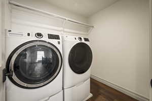 Laundry area featuring washer and dryer and dark wood-style floors