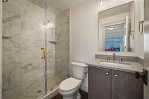 Bathroom with a marble finish shower, a textured ceiling, vanity, and ensuite bathroom