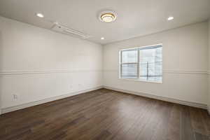 Unfurnished room featuring dark wood finished floors, a textured ceiling, and recessed lighting