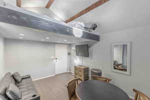 Living room with wood finished floors, recessed lighting, beam ceiling, and high vaulted ceiling