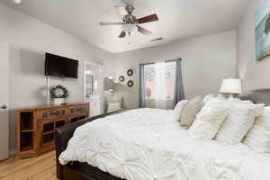 Bedroom featuring ceiling fan, light wood-type flooring, and ensuite bathroom