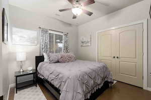 Bedroom featuring tile patterned flooring, a closet, and a ceiling fan