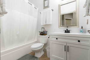 Bathroom with shower / bath combo with shower curtain, vanity, and light tile patterned flooring
