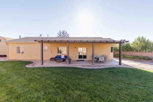 Rear view of property featuring stucco siding, a patio, and an outdoor living space