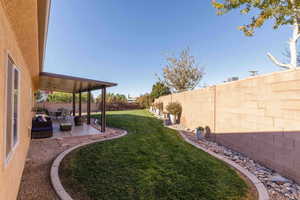 Fenced backyard featuring a patio, an outdoor hangout area, and ceiling fan