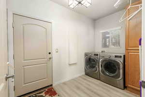 Laundry room featuring light wood-style flooring and washing machine and dryer