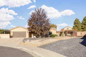 View of front facade with stucco siding, concrete driveway, a garage, and a gate