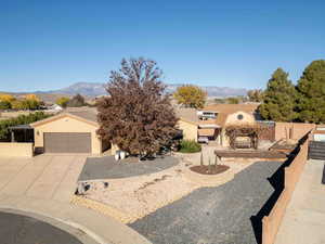 View of front of house featuring stucco siding, a mountain view, and concrete driveway