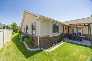 Back of house featuring stucco siding, a fenced backyard, brick siding, and a patio