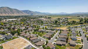Aerial view of property and surrounding area with a mountainous background and nearby suburban area