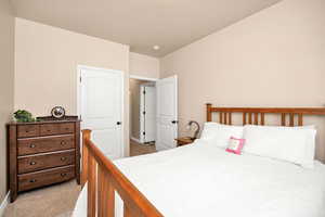 Bedroom with light colored carpet and baseboards
