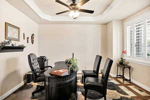 Home office featuring ornamental molding, a raised ceiling, and ceiling fan