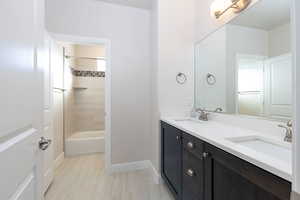Bathroom with double vanity and shower / bath combination