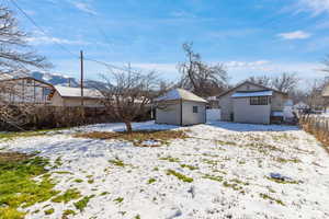 Yard covered in snow featuring an outbuilding
