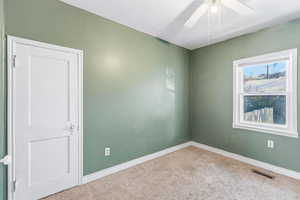 Empty room featuring carpet flooring and ceiling fan