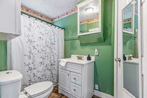 Bathroom with curtained shower, vanity, and a textured ceiling