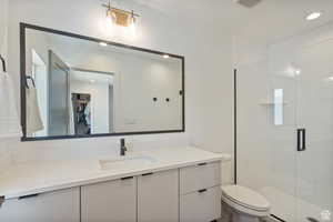 Full bathroom featuring vanity, a walk in closet, a shower stall, and recessed lighting