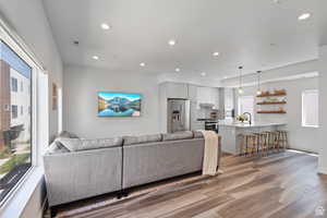 Living room with healthy amount of natural light, recessed lighting, and light wood-style flooring