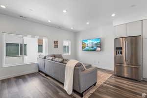 Living area with dark wood-style flooring and recessed lighting
