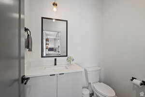Powder room on main floor for guests featuring vanity and toilet