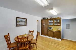 Dining space featuring light wood-style flooring and electric panel
