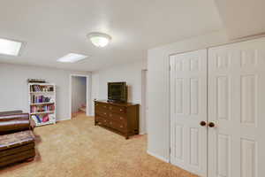 Sitting room featuring light carpet, stairs, and a textured ceiling