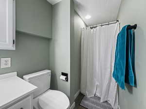 Full bathroom featuring a shower stall, vanity, a textured ceiling, and dark wood-type flooring