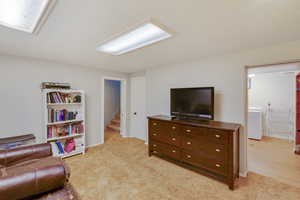 Living area with washer / dryer and light carpet