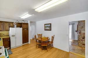 Dining room featuring light wood-type flooring and a textured ceiling