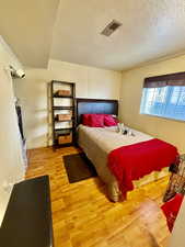 Bedroom featuring light wood finished floors and a textured ceiling