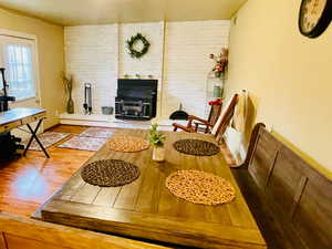 Dining area with a textured ceiling, light wood-style flooring, and a wood stove
