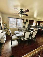 Dining space featuring dark wood finished floors, a textured ceiling, and a ceiling fan