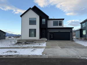 View of front of property with driveway, an attached garage, and a mountain view
