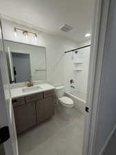 Full bathroom featuring vanity, shower / bath combination, a textured ceiling, and light tile patterned flooring