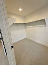 Spacious closet featuring light colored carpet