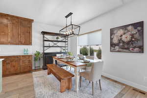 Dining room with light wood-style flooring and a chandelier