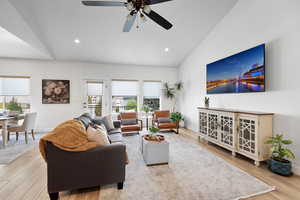Living room with light wood finished floors, vaulted ceiling, recessed lighting, and a ceiling fan