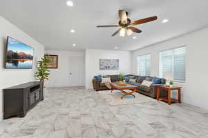 Living room featuring recessed lighting, a ceiling fan, and light marble finish flooring