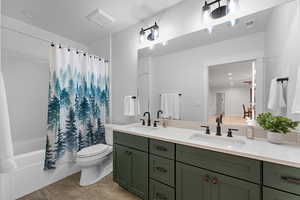 Full bathroom featuring double vanity and shower / bath combo