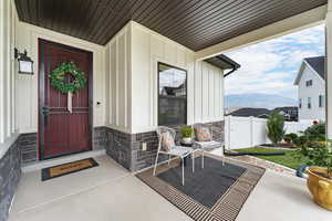 View of exterior entry featuring stone siding, board and batten siding, and a mountain view